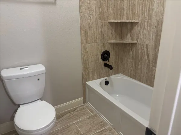 a white toilet sitting next to a bath tub