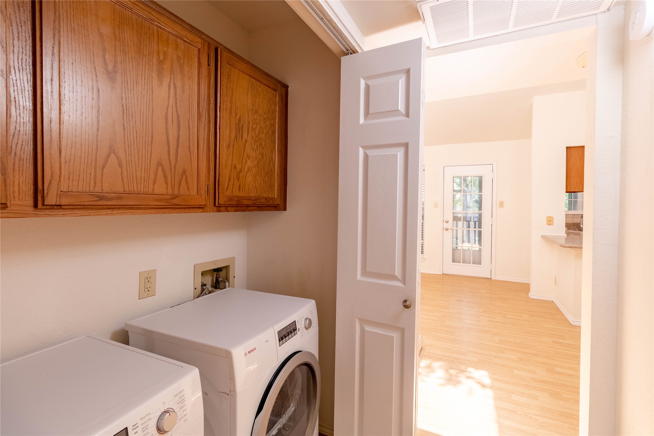 3809 Spicewood Springs Road, Unit 253 Austin, TX 78759 - Photo 12 of 23 Laundry area featuring washer and clothes dryer, light wood finished floors, and cabinet space
