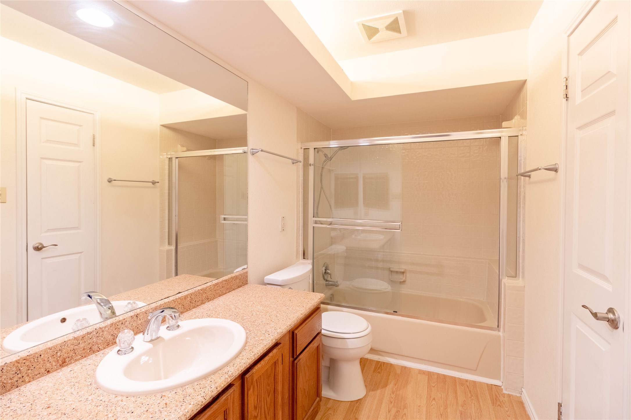 3809 Spicewood Springs Road, Unit 253 Austin, TX 78759 - Photo 13 of 23 Bathroom featuring vanity, light wood finished floors, and shower / bath combination with glass door