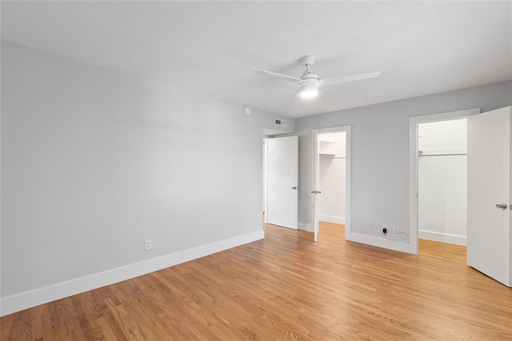 10727 Villager Road, Unit C Dallas, TX 75230 - Photo 29 of 39 Unfurnished bedroom with a spacious closet, light wood-style flooring, and ceiling fan
