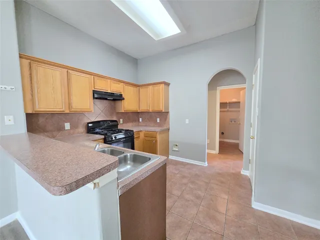 a kitchen with stainless steel appliances granite countertop a sink a stove and a refrigerator