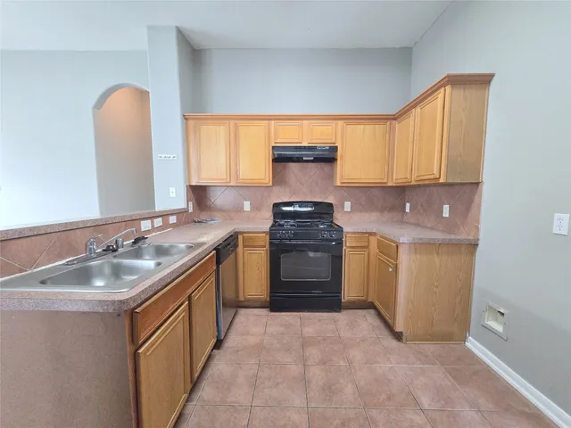 a kitchen with a sink stove top oven and cabinets