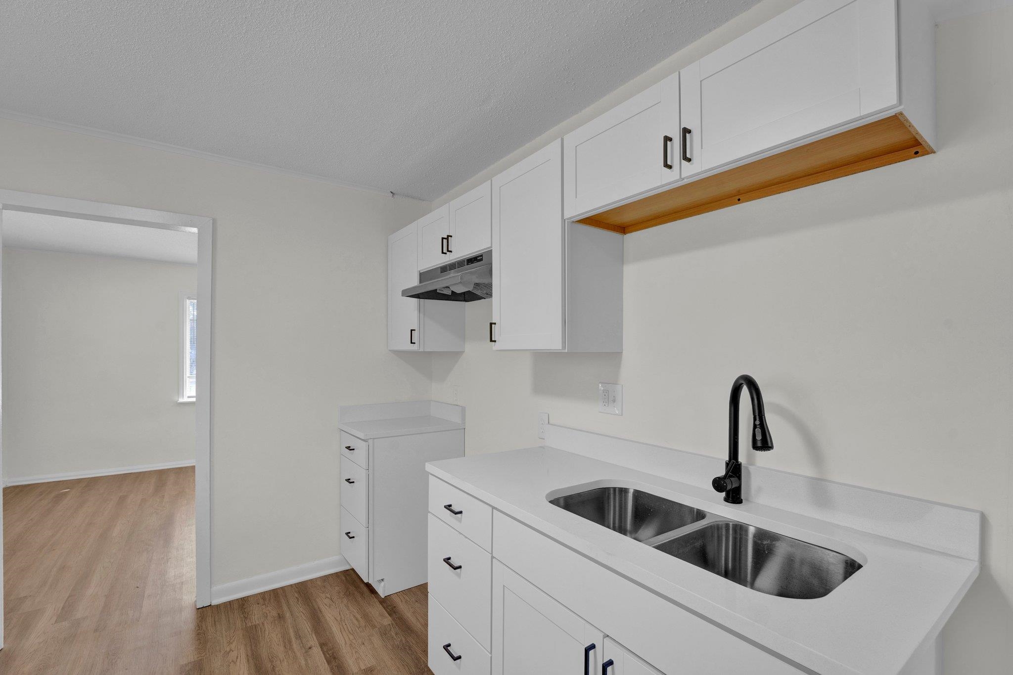 7829 Admiral Road Millington, TN 38053 - Photo 15 of 28 Kitchen featuring white cabinetry, light wood-type flooring, a textured ceiling, and sink