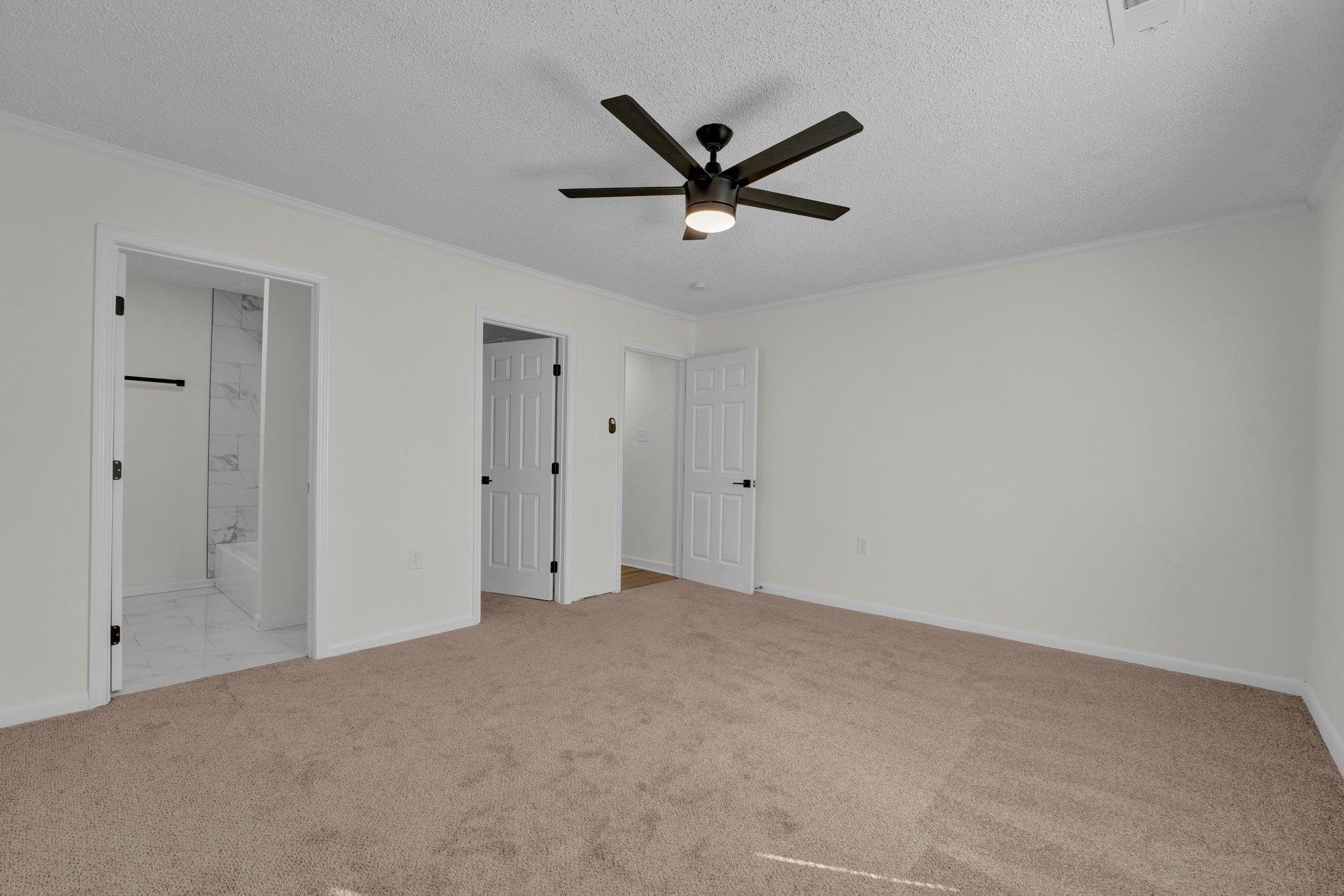 7829 Admiral Road Millington, TN 38053 - Photo 21 of 28 Unfurnished bedroom with ensuite bathroom, ceiling fan, a textured ceiling, and light colored carpet