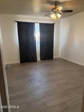 an empty room with windows and fan