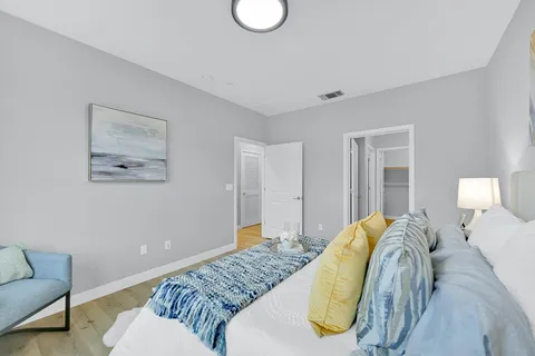 a bedroom with a bed and wooden floor