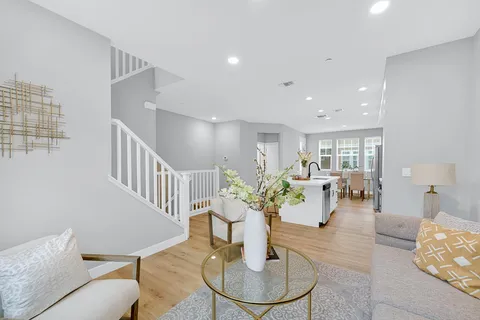 a living room with furniture flowers and a dining table