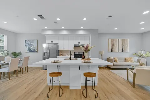 a view of a dining room with furniture a rug and wooden floor