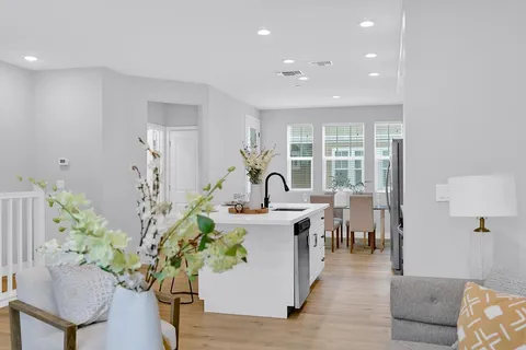 a kitchen with kitchen island granite countertop a sink a stove and a refrigerator