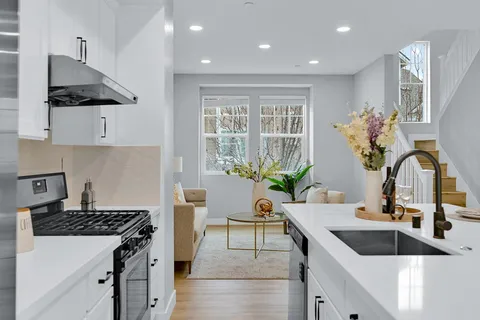 a large kitchen with stainless steel appliances granite countertop a lot of counter space and a sink