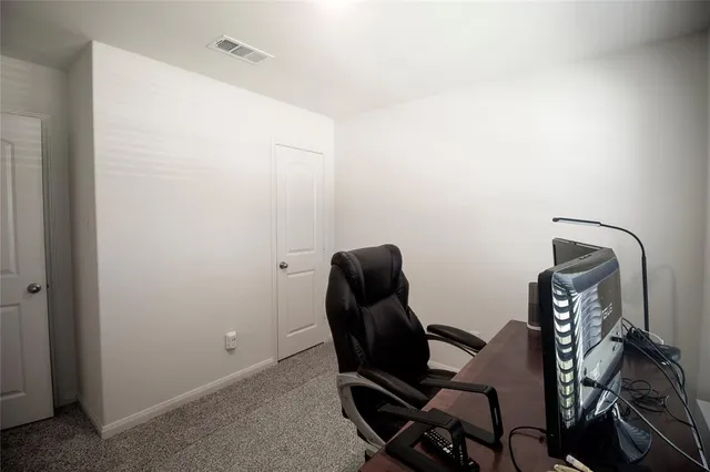 a view of a workspace with furniture and a window