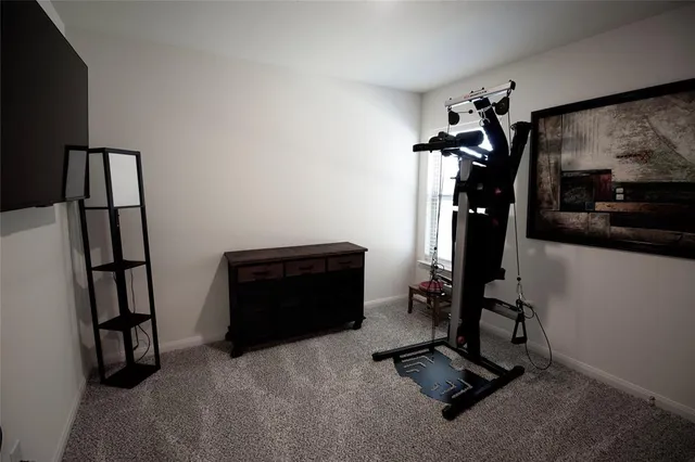a room with gym equipment and a view of living room