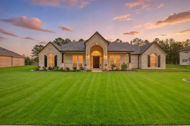 a front view of a house with a garden and yard