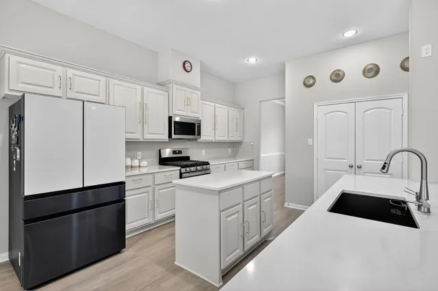 a kitchen with white cabinets and stainless steel appliances