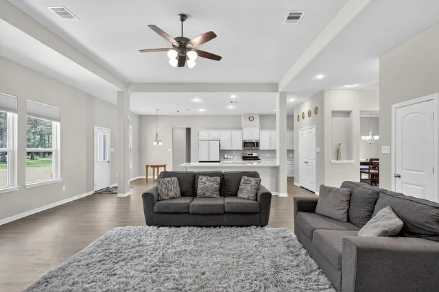a living room with furniture and a view of kitchen