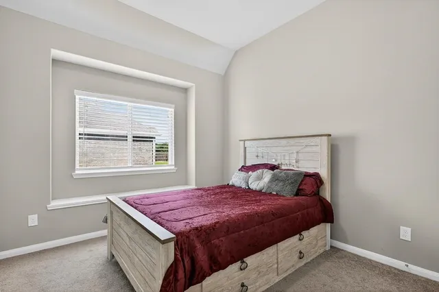 a bed sitting in a bedroom next to a window