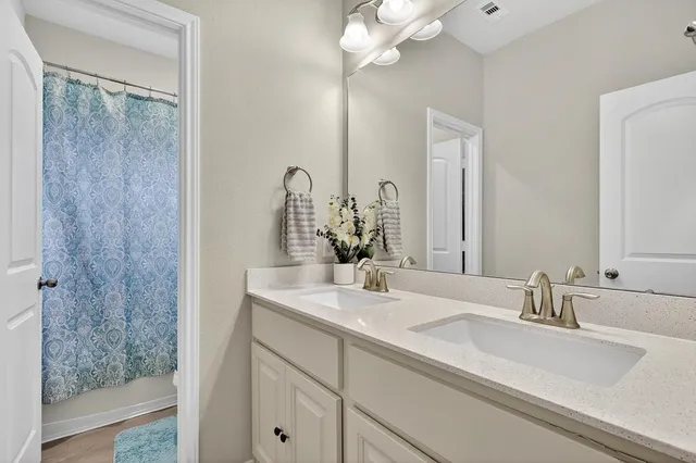 a bathroom with double vanity sink a vanity and a mirror