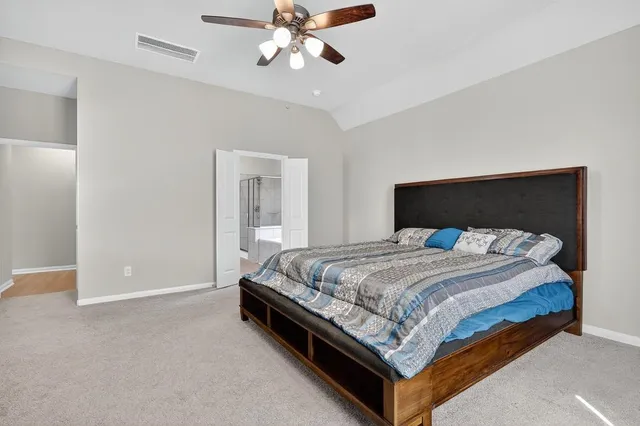 a bed sitting in a bedroom and a chandelier