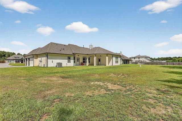 a view of a big house with a big yard and large trees