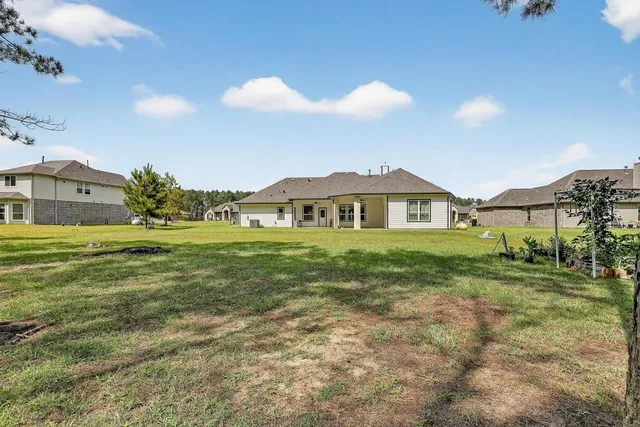 a view of a big house with a big yard and large trees