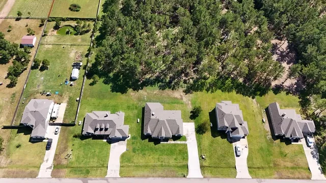 aerial view of a house with a yard and parking spaces