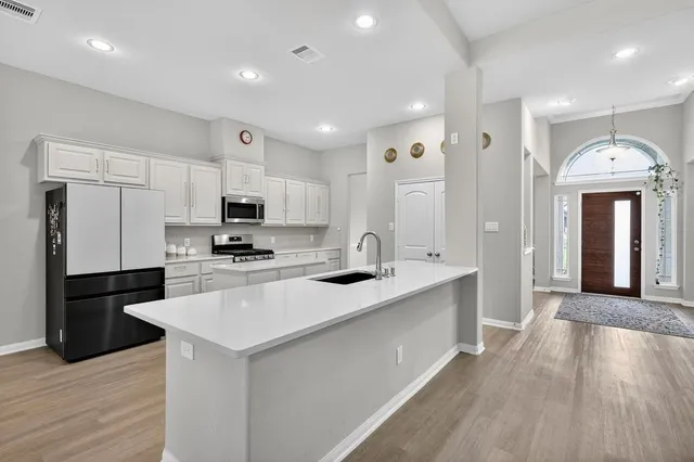 a kitchen with stainless steel appliances kitchen island granite countertop a sink and cabinets