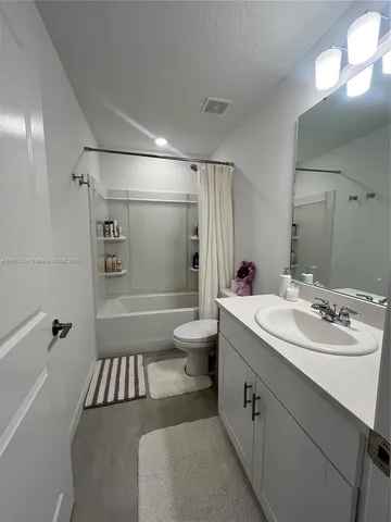 a bathroom with a double vanity sink toilet mirror and shower