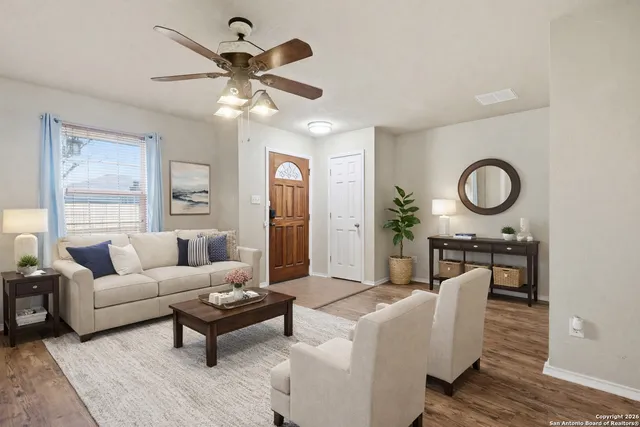 a living room with furniture a window and a clock