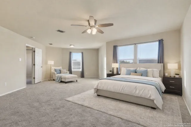 a spacious bedroom with a bed and a chandelier