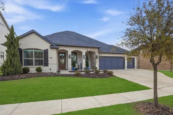 a front view of a house with a garden and yard