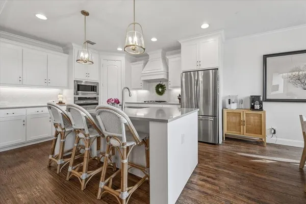 a kitchen that has a table chairs refrigerator and cabinets