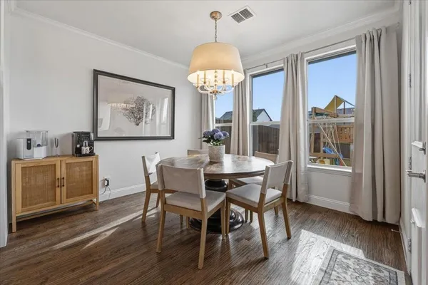 a dining room with furniture a chandelier and wooden floor