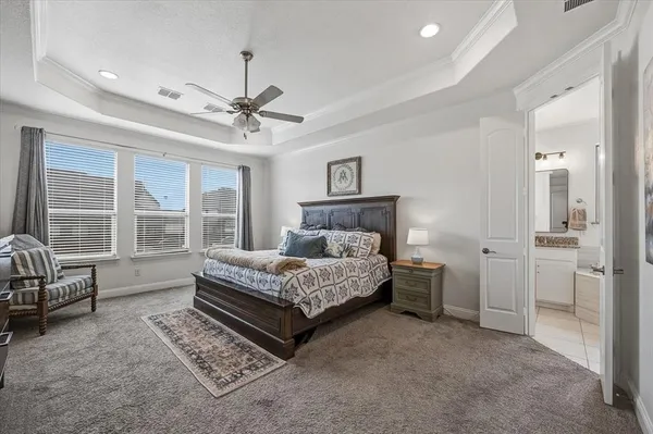 a spacious bedroom with a bed a couch and large window