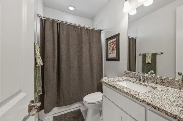 a bathroom with a granite countertop sink toilet and shower
