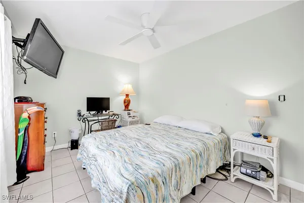 a bedroom with a bed a flat screen tv and a chandelier