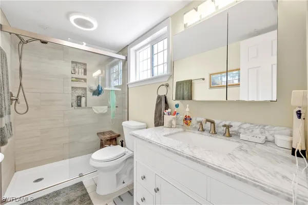 a bathroom with a sink a toilet and shower