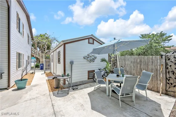 a view of a patio with table and chairs and potted plants