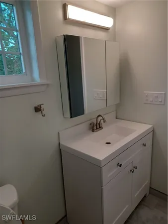 a bathroom with a sink toilet and mirror