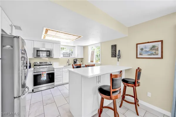 a kitchen with stainless steel appliances a stove a sink refrigerator and a refrigerator with wooden floor