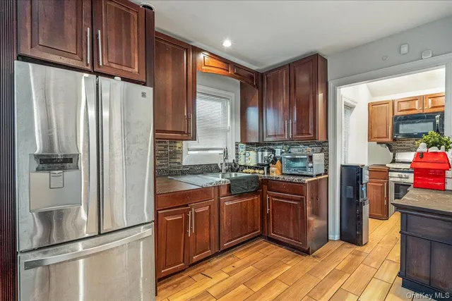 a kitchen with stainless steel appliances granite countertop a refrigerator and a stove top oven
