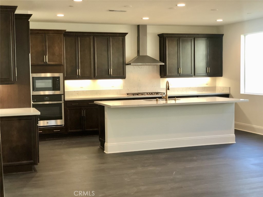 39538 Verbena Way Temecula, CA 92591 - Photo 6 of 38 a kitchen with kitchen island granite countertop wooden cabinets and stainless steel appliances