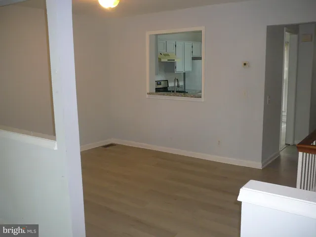 a view of a room with wooden floor and a bathroom