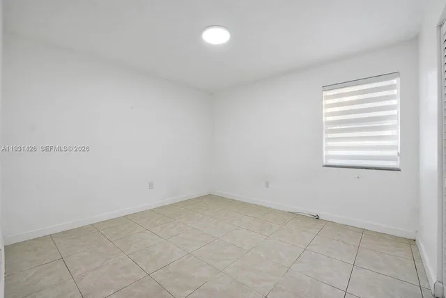 an empty room with kitchen space and windows