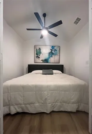a bedroom with a bed and painting on the wall