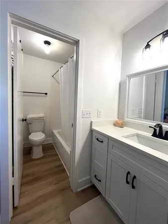 a spacious bathroom with a double vanity sink a toilet and a mirror