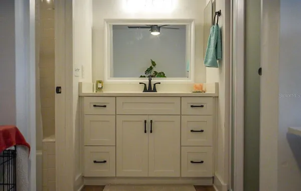 a bathroom with a sink vanity and mirror