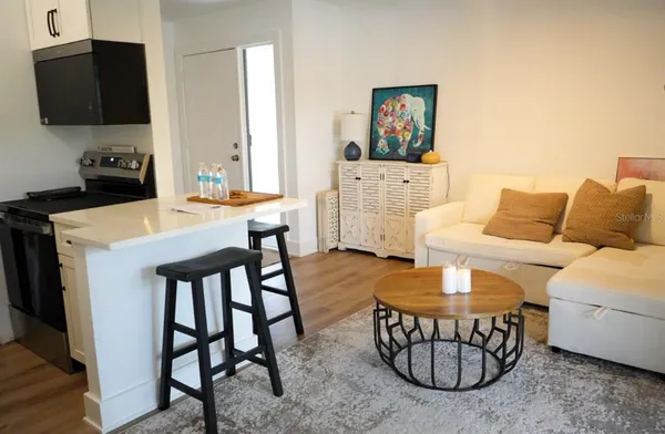 a living room with furniture a flat screen tv and a table