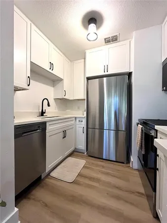 a kitchen with a sink stainless steel appliances and refrigerator