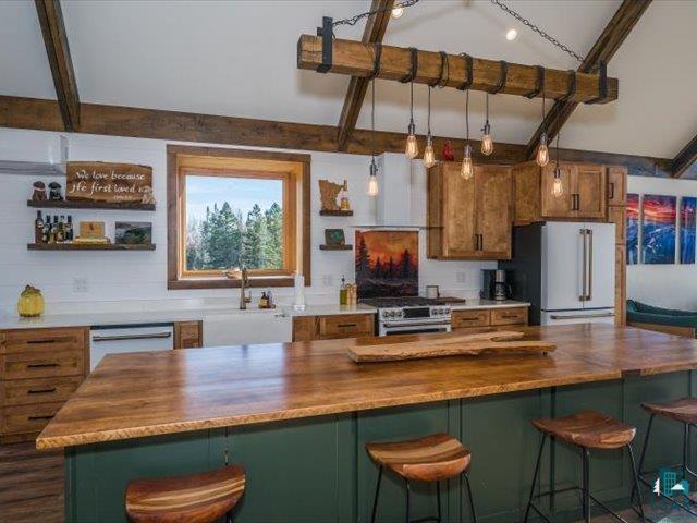 5508 Nordling Road Duluth, MN 55804 - Photo 11 of 58 Kitchen with green cabinets, a breakfast bar, butcher block countertops, open shelves, and beam ceiling