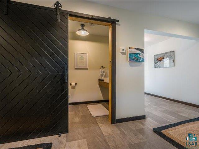 5508 Nordling Road Duluth, MN 55804 - Photo 20 of 58 Corridor with light wood-style flooring and a barn door